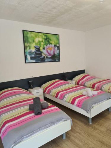 two beds in a bedroom with a painting on the wall at Studio 3 lits in Saint-Louis