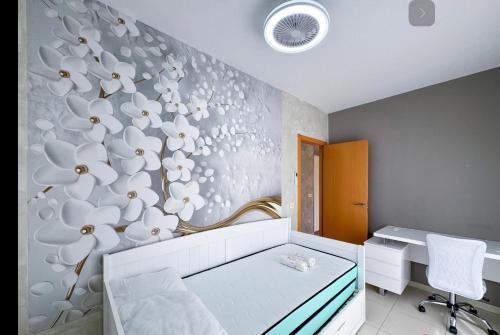 a bedroom with a white bed with a flower wall at Pasarla rico in Torreblanca