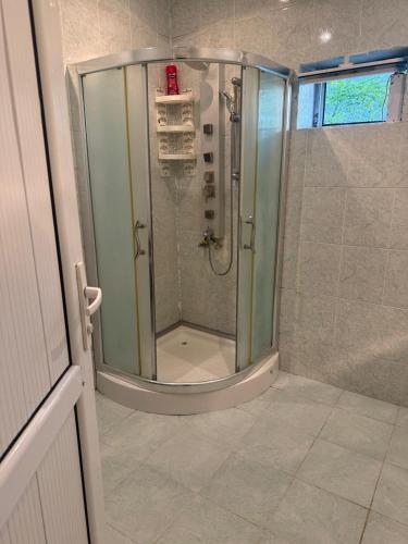 a shower with a glass door in a bathroom at Gabala mountain house in Gabala