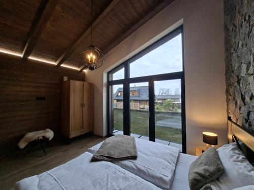 a bedroom with a bed and a large window at Chalet Johannes in Liptovský Ján