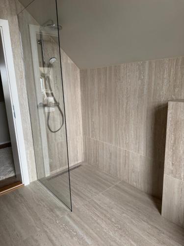 a shower with a glass door in a bathroom at ScenicOceanview 4Free parking space 18 mins Downtown in Álftanes
