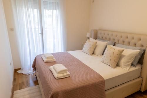 a bedroom with a large bed with towels on it at Lumi Apartment in Podgorica