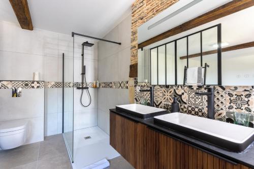 a bathroom with two sinks and a shower at Domaine Cherps Spa - Sérénité in Vielleségure