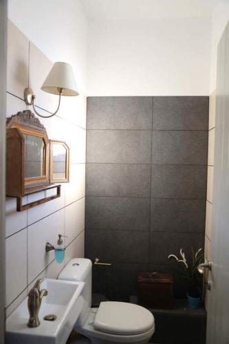 a bathroom with a white toilet and a sink at Villa Lina Syros in Azolimnos Syros