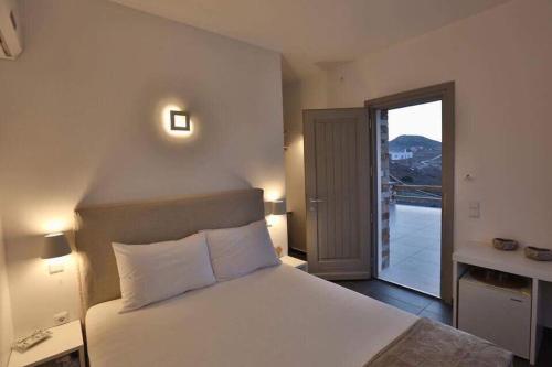a bedroom with a large bed and a balcony at Villa Lina Syros in Azolimnos Syros