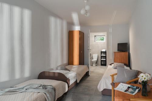 a room with three beds and a bathroom with a television at Rewita Pieczyska in Koronowo