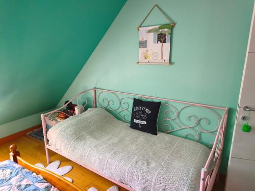 a bed in a room with a blue wall at Sous le pommier in Douvres-la-Délivrande