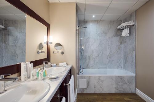 ein Badezimmer mit zwei Waschbecken und einer Badewanne in der Unterkunft Rock Hotel in Gibraltar
