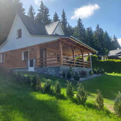 a large wooden house with a grass yard at Chata Jeřabina in Klíny
