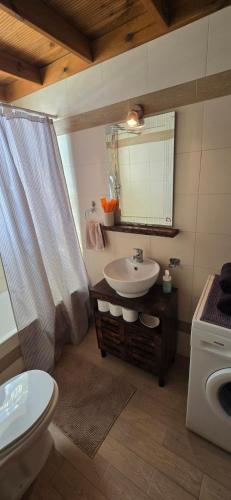 a bathroom with a sink and a toilet and a mirror at Dimitra's Maisonette at Rafaella Resort in Kokóni