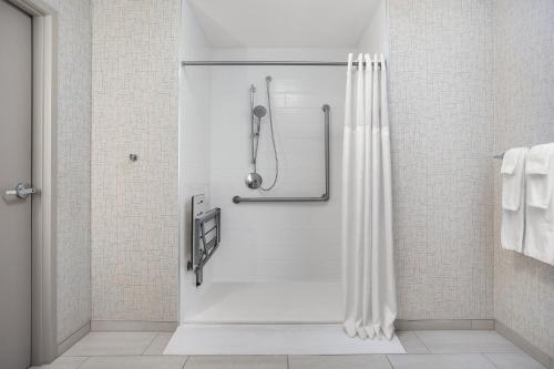 a shower with a white shower curtain in a bathroom at Holiday Inn Express & Suites - Aurora by IHG in Aurora