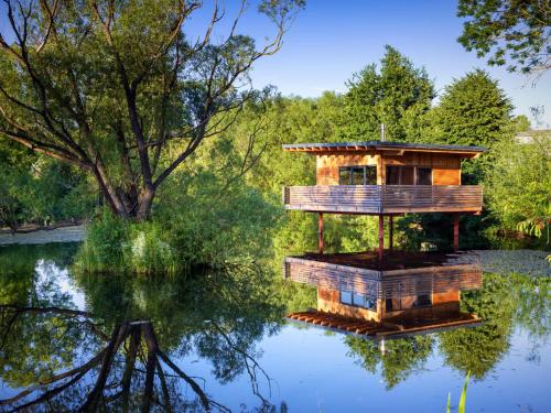 ein Baumhaus mitten in einem See in der Unterkunft Spektakuläres Tiny House im Teich mit Terrasse und Kamin in Großharthau