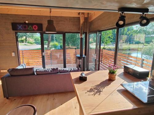 ein Wohnzimmer mit Sofa und Tisch in der Unterkunft Spektakuläres Tiny House im Teich mit Terrasse und Kamin in Großharthau
