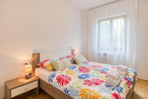 a bedroom with a bed with a colorful bedspread at Apartman Maria Pia in Lovran