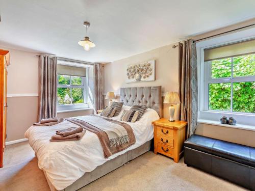 a bedroom with a large bed and two windows at 2 Bed in Morpeth oc-cn049 in Acklington