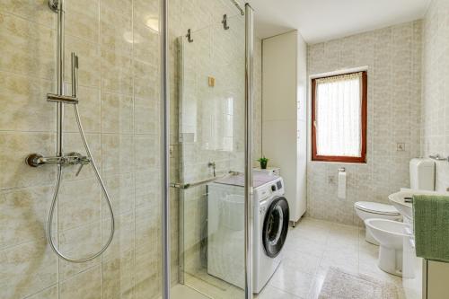 a bathroom with a shower and a washing machine at Apartman Maria Pia in Lovran