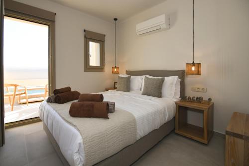 a bedroom with a large bed and a balcony at Santorini - Villa - Sleeps 4 - Pool - Parking in Mesaria