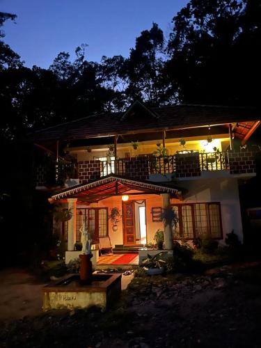 a house lit up at night with a porch at Reevilla in Madikeri