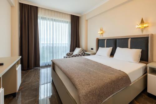 a hotel room with a large bed and a window at Asil Luxury Boutique in Burhaniye
