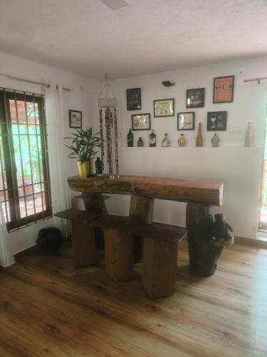 a room with a wooden table and a bench at Reevilla in Madikeri