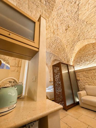 a kitchen with a counter and a stone wall at Il Balcone di Anna - Luxury Homes in Ceglie Messapica