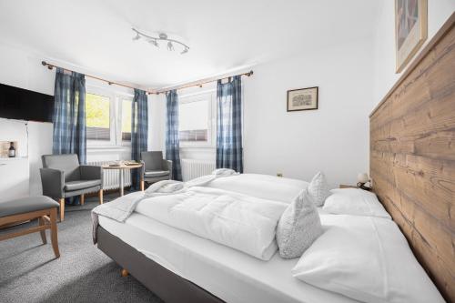 a bedroom with a large white bed in a room at Pension Domblick in Wetzlar