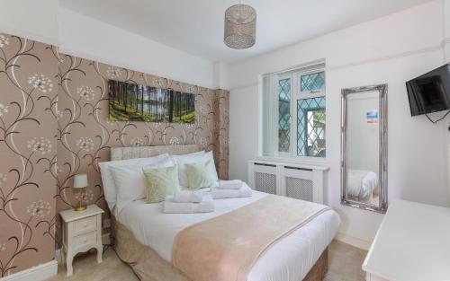 a bedroom with a large white bed and a window at Undercliff View - St Lawrence Retreat in Saint Lawrence