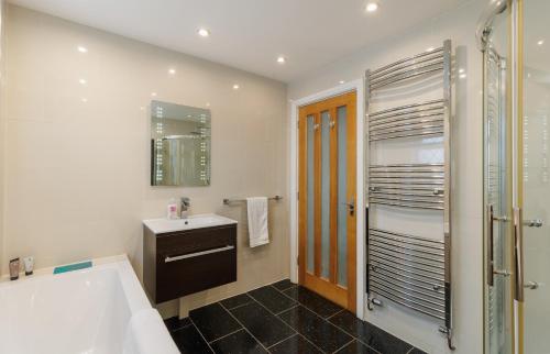 a bathroom with a tub and a sink and a shower at Undercliff View - St Lawrence Retreat in Saint Lawrence