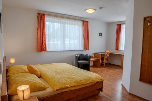 a bedroom with a bed and a desk and a table at Ferienwohnung Schretthauser in Bad Mitterndorf