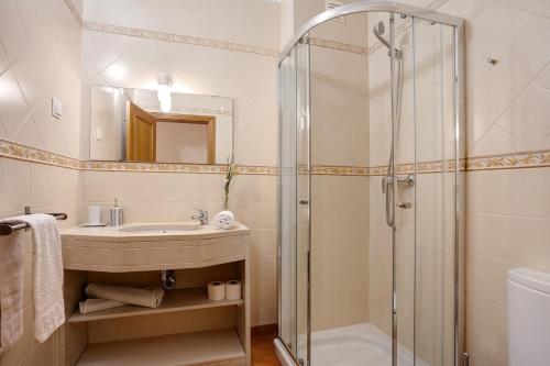 a bathroom with a sink and a shower at SunHome - Casas de férias em Portimao in Portimão