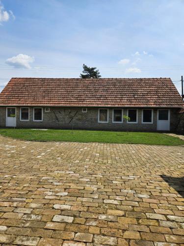 a house with a brick driveway in front of it at Apartmany Detvanka in Bački Petrovac
