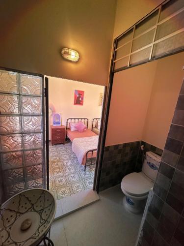 a small bathroom with a toilet and a bedroom at The Mê Linh House in Nha Trang
