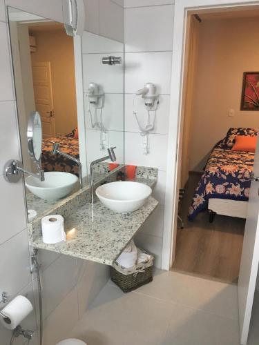 a bathroom with two sinks and a bed at Hospedaria Conceitual in Florianópolis