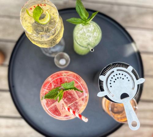 a black table topped with two cocktails and a juicer at Hôtel Escaletto in Aix-en-Provence