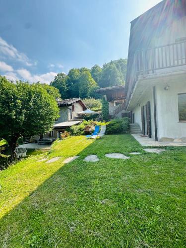 a yard next to a building with a grassy yard at Joy Center - Casa e Appartamenti Vacanza in Val Pellice in Villar Pellice