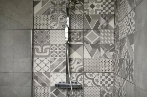 a shower in a bathroom with a tile wall at Zaks House Valle San Lorenzo in Arona