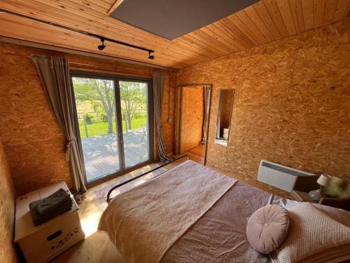 a bedroom with a bed and a large window at Meadows - Eco Retreat in Bitton