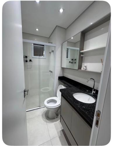 a bathroom with a shower and a toilet and a sink at Apartamento Garden com churrasqueira área Gourmet in Bauru
