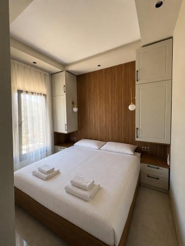 a bedroom with a large white bed with towels on it at Olea Stone Houses in Bodrum City