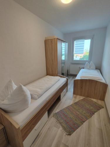 a bedroom with two beds and a window at Monteurwohnungen Bad Langensalza in Bad Langensalza