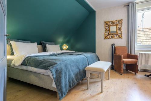 a bedroom with a large bed and a chair at Chez Noëlle - Piscine in Sélestat