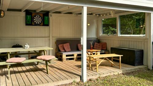 a porch with a picnic table and a table and chairs at Cottage Near Forest And Beach in Glesborg