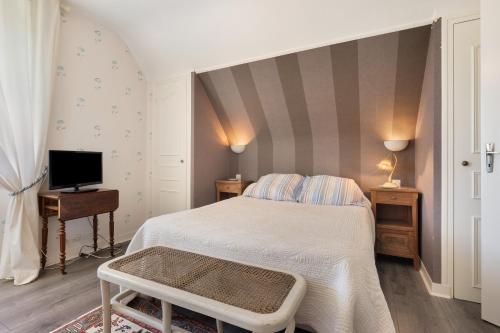 a small bedroom with a bed and a tv at Chambres D'hôtes Kergollay in Lanhouarneau
