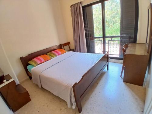 a bedroom with a bed and a large window at Miltos beach House in Larnaca