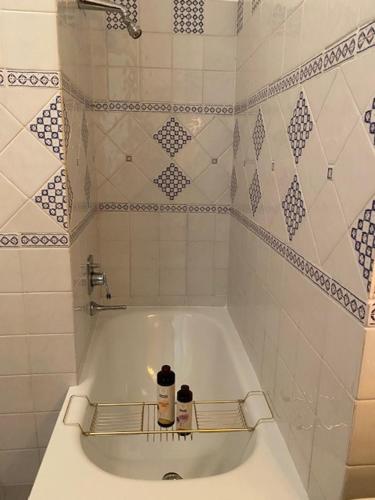 a bath tub in a bathroom with white tiles at Sul fiume di Varallo in Varallo