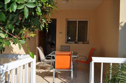 un comedor con sillas naranjas y una mesa en Sunset Garden Villa, en Perivolia