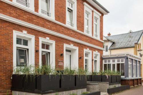 a brick building with plants in front of it at Pier17 Appartement 2 in Borkum