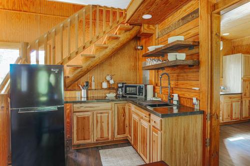 a kitchen with a black refrigerator and wooden walls at Blue's Barn in Nellysford