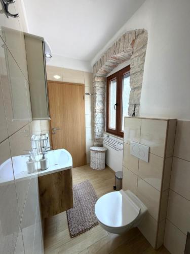 a bathroom with a white sink and a toilet at Tea Rooms in Bale