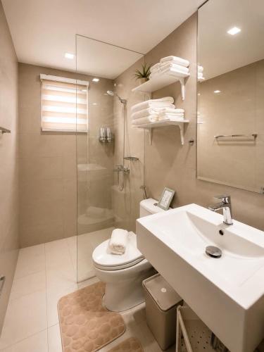 a bathroom with a sink and a toilet and a shower at Oasis 8 in Bacolod